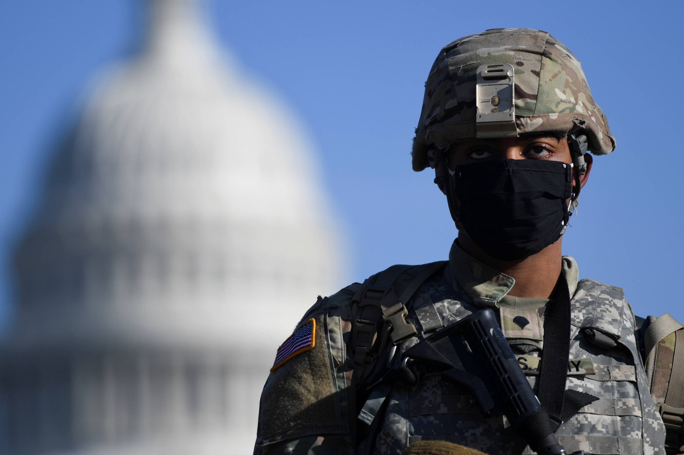 A member of the National Guard stands near the U.S. Capitol building on Wednesday, as the House of Representatives debated impeaching U.S. President Donald Trump a week after his supporters stormed the Capitol building in Washington. | REUTERS
