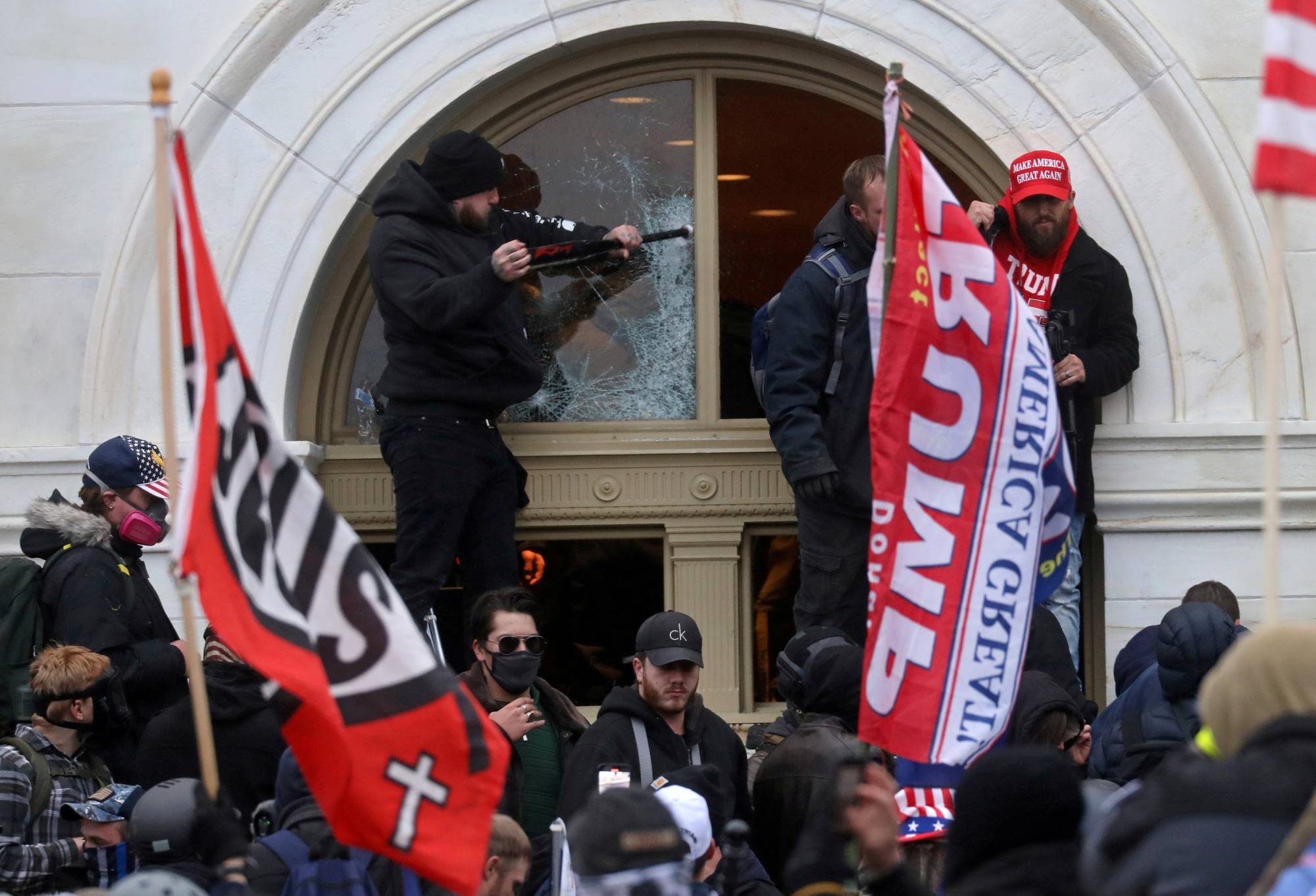 A man breaks a window as a mob of supporters of U.S. President Donald Trump storm the Capitol building in Washington on Jan. 6. | REUTERS