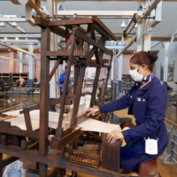 A staff member demonstrates the technology behind one of the earliest looms. | JANE KITAGAWA