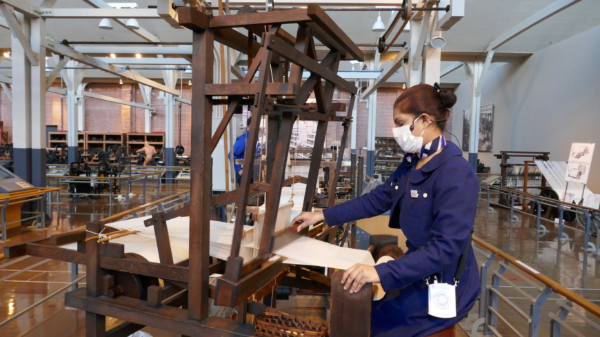 A staff member demonstrates the technology behind one of the earliest looms. | JANE KITAGAWA