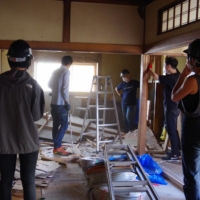 Student volunteers and young artisans work to convert a vacant home into a guest house in Ishinomaki, Miyagi Prefecture, in June.