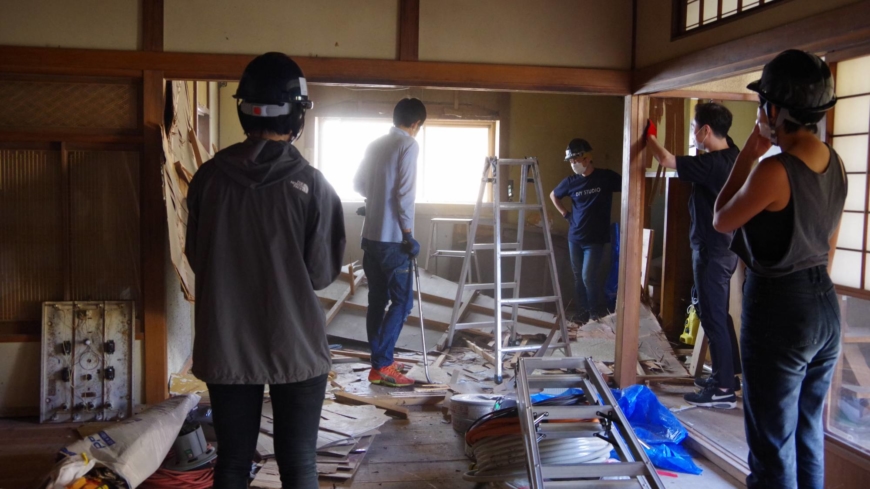 Student volunteers and young artisans work to convert a vacant home into a guest house in Ishinomaki, Miyagi Prefecture, in June.