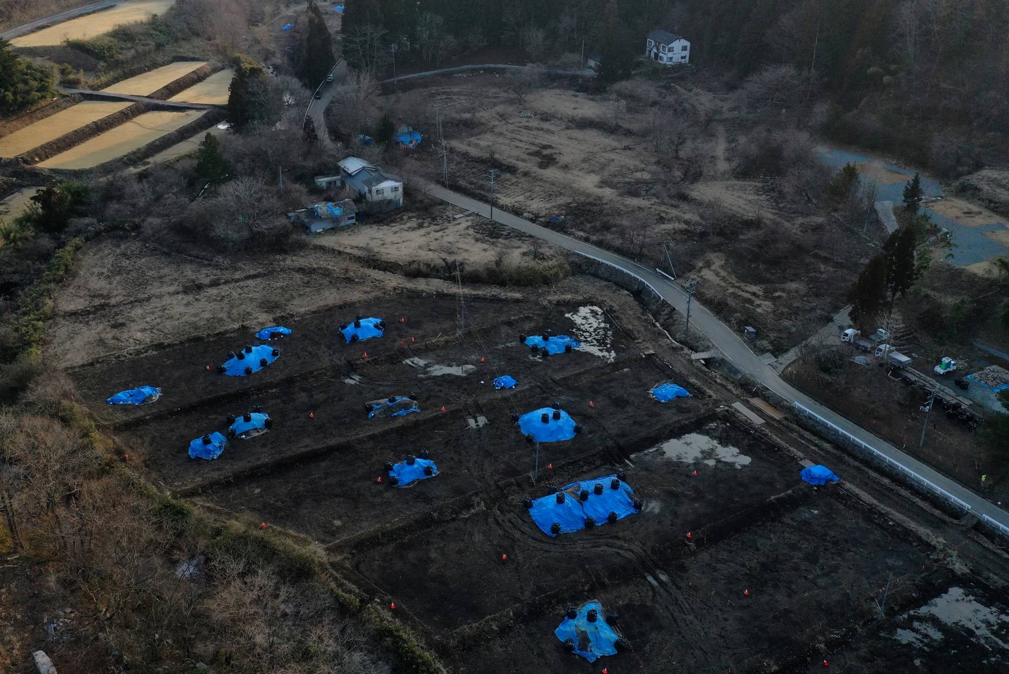 Sakae Kato's house stands close to a field which is being decontaminated in a restricted zone in Fukushima Prefecture. | REUTERS