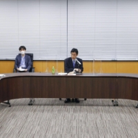 J. League Chairman Mitsuru Murai (left) and NPB Commissioner Atsushi Saito (right) meet with Yasutoshi Nishimura, the minister in charge of Japan’s coronavirus response, on Monday. | KYODO