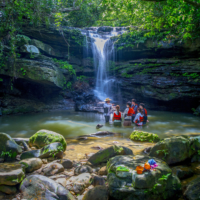 Trekkers explore a waterfall on Iriomote Island. | OCVB