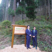 Watanabe (left) and Hirano stand in front of the forest where Asteria conserves cedar trees under a partnership with the town of Oguni. | ASTERIA