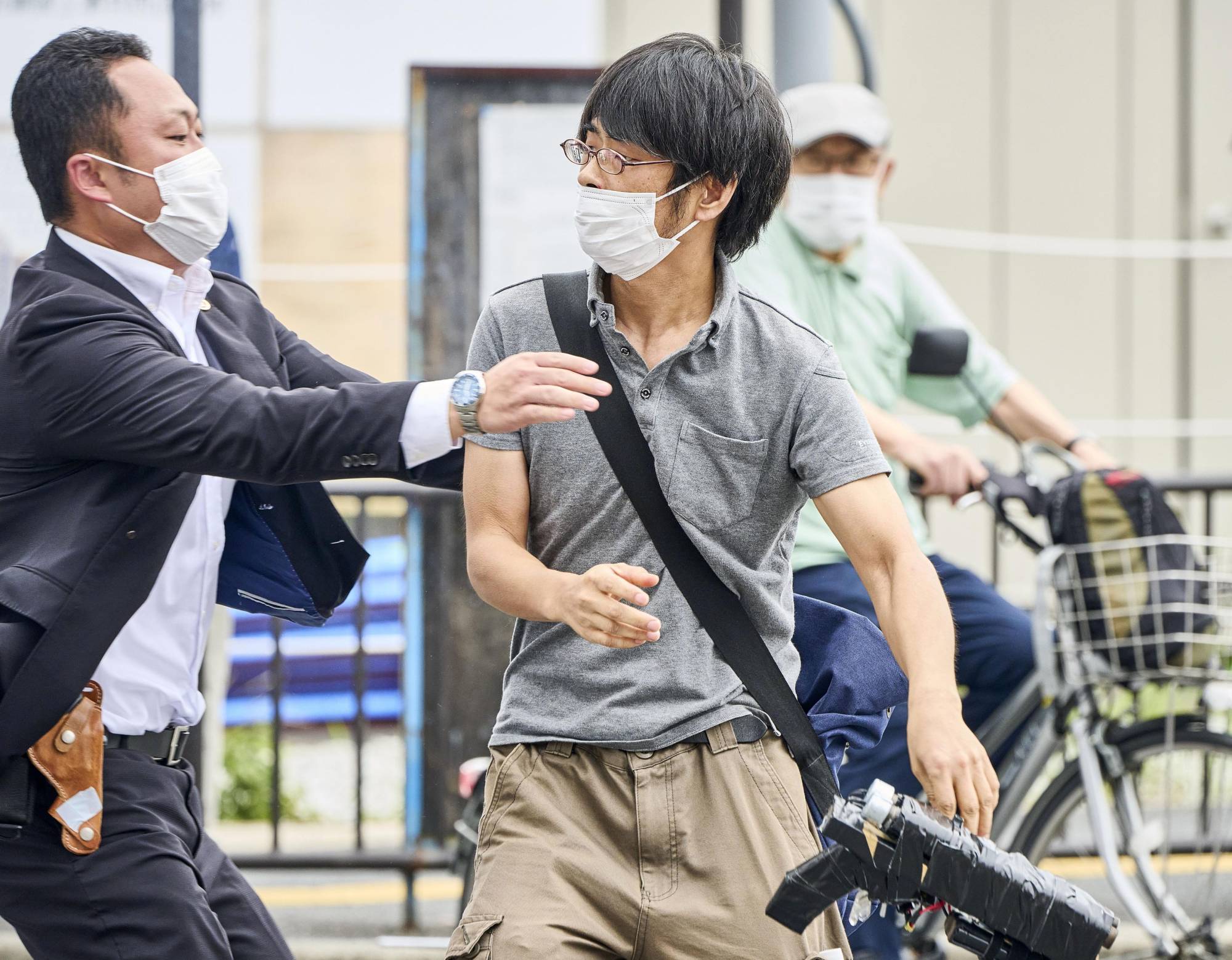 Tetsuya Yamagami is grabbed by a security personnel after allegedly shooting Abe in Nara on Friday. | KYODO