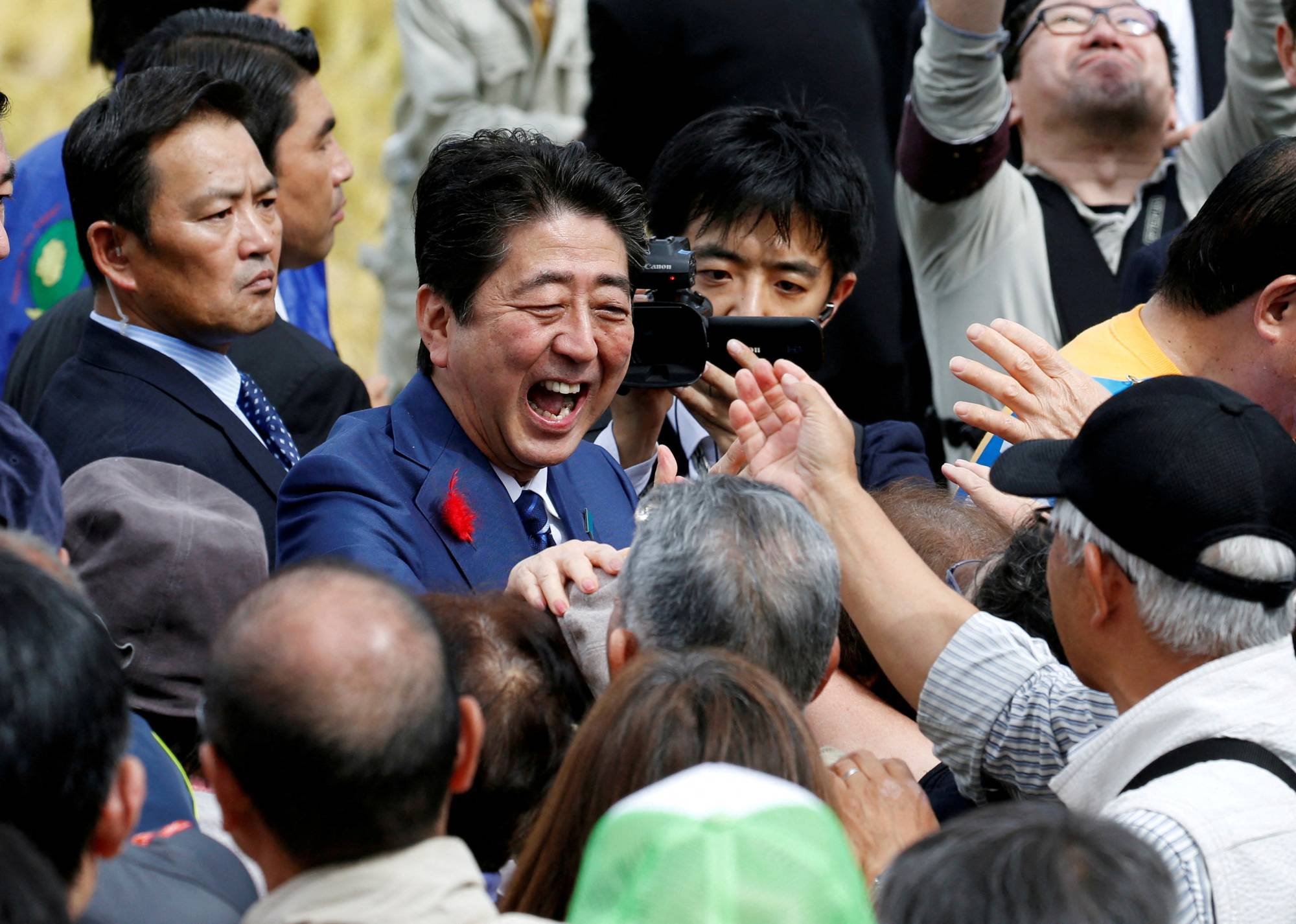 Abe shakes hands with supporters after a Lower House election campaign rally in Fukushima in October 2017. | REUTERS
