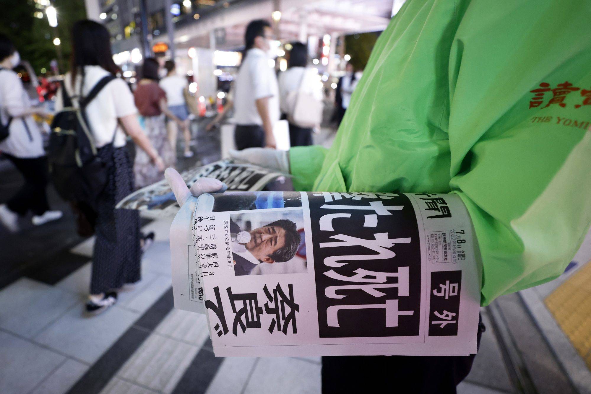 Copies of an extra edition of the Yomiuri Shimbun newspaper are distributed in Tokyo on Friday . | BLOOMBERG