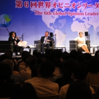 Worldwide Support for Development Chairman and Japan Forum on International Relations Director Haruhisa Handa (left) welcomes panelists on stage at the sixth Global Opinion Leaders Summit on July 28 in Tokyo. | TTJ TACHIBANA PUBLISHING