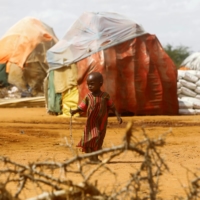 A child walks outside makeshift shelters for people displaced by the country’s severe droughts at the Kaxareey camp in Dollow, Somalia, on May 24. | REUTERS