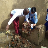 A city of Yokohama Waterworks employee shows a worker a new water meter in Malawi in 2019. | YOKOHAMA MUNICIPAL GOVERNMENT