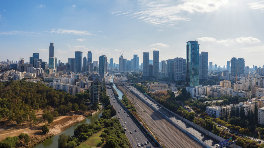 Aerial view of Tel Aviv skyline with urban skyscrapers at sunset and cars on Ayalon highway, Israel