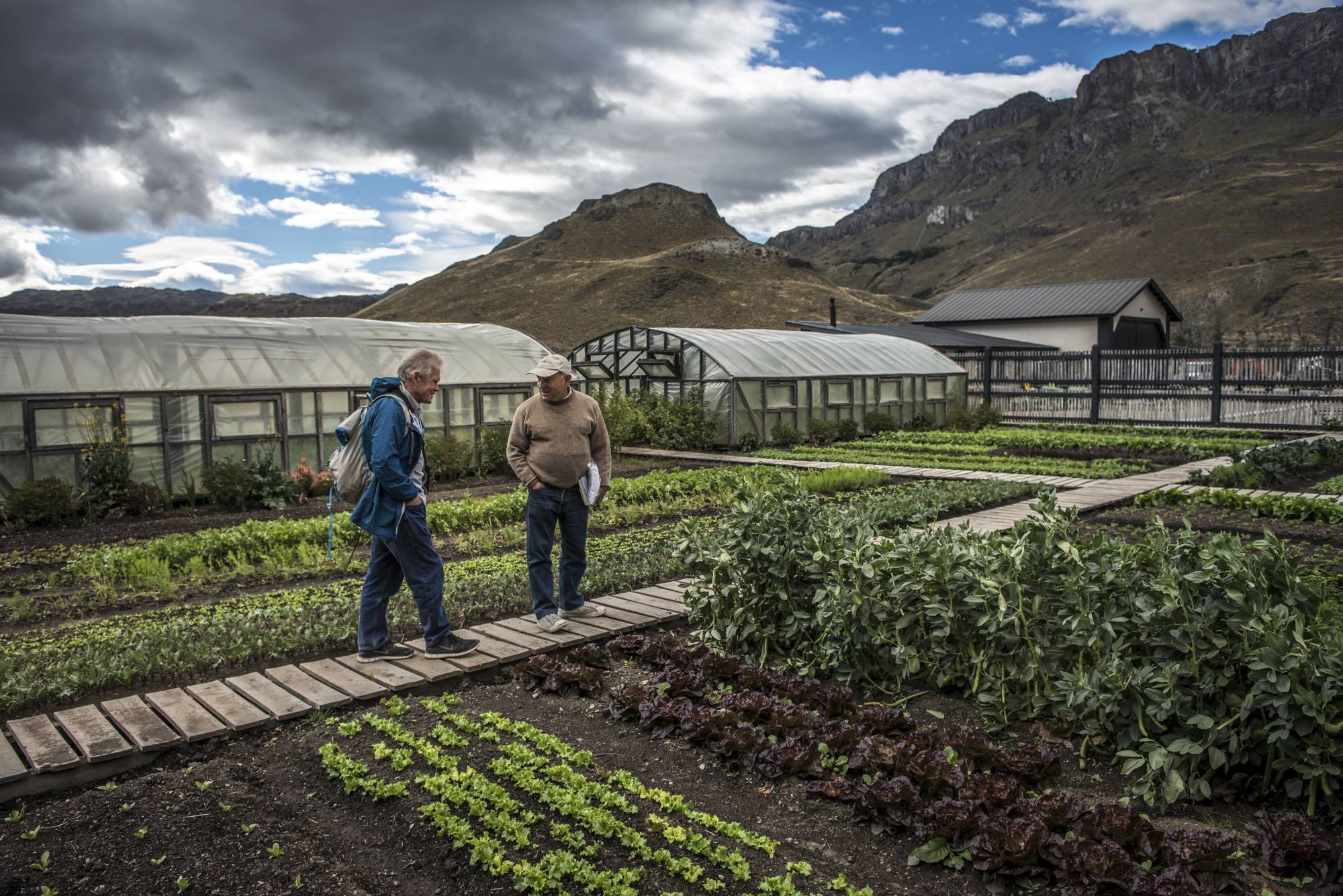 Chouinard (center) at organic gardens that supply a restaurant in Patagonia National Park, Chile, in January 2018. | MERIDITH KOHUT / THE NEW YORK TIMES