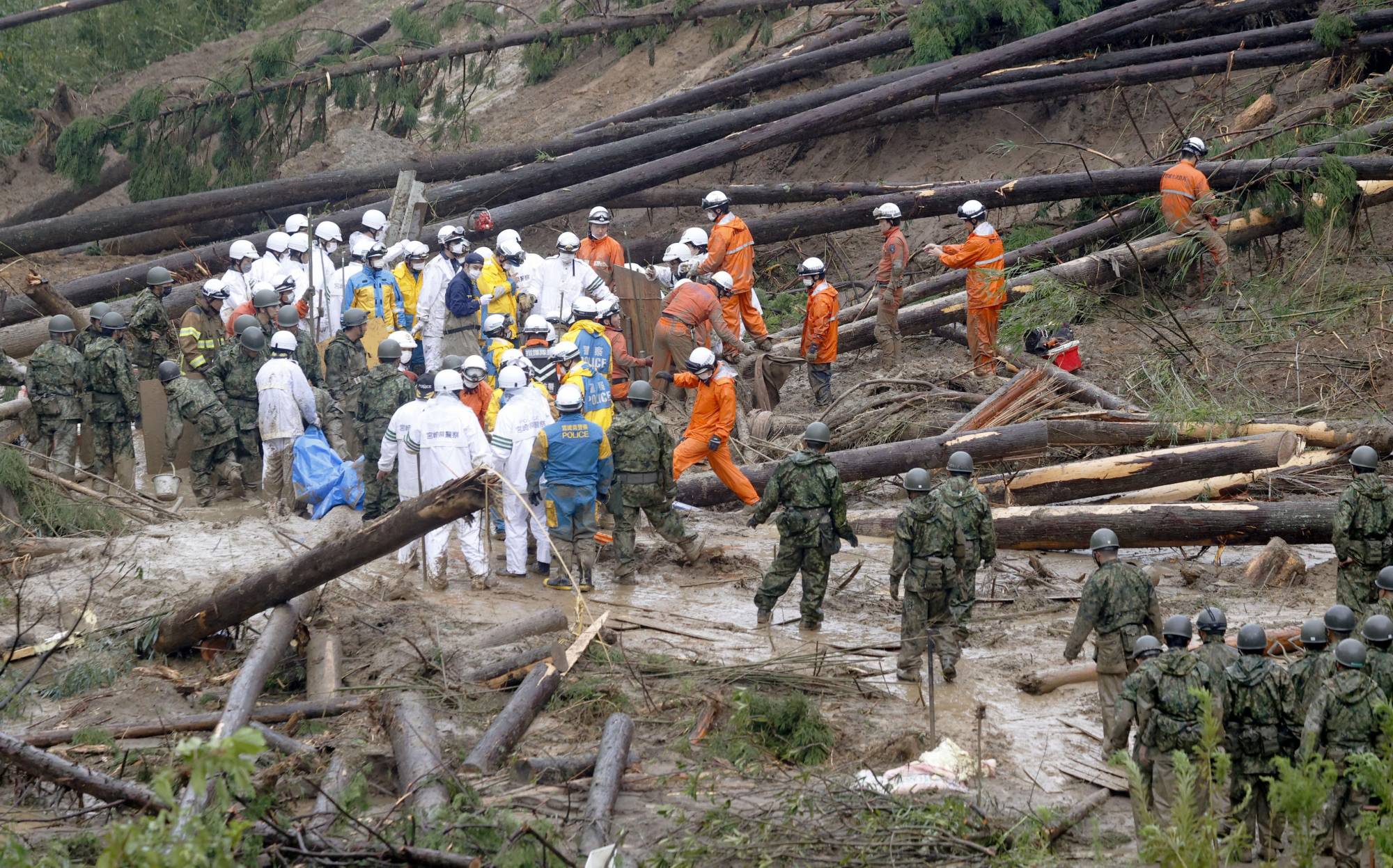 Rescuers search the area of a mudslide where a man in his 40s went missing in Mimata, Miyazaki Prefecture, on Monday. | KYODO