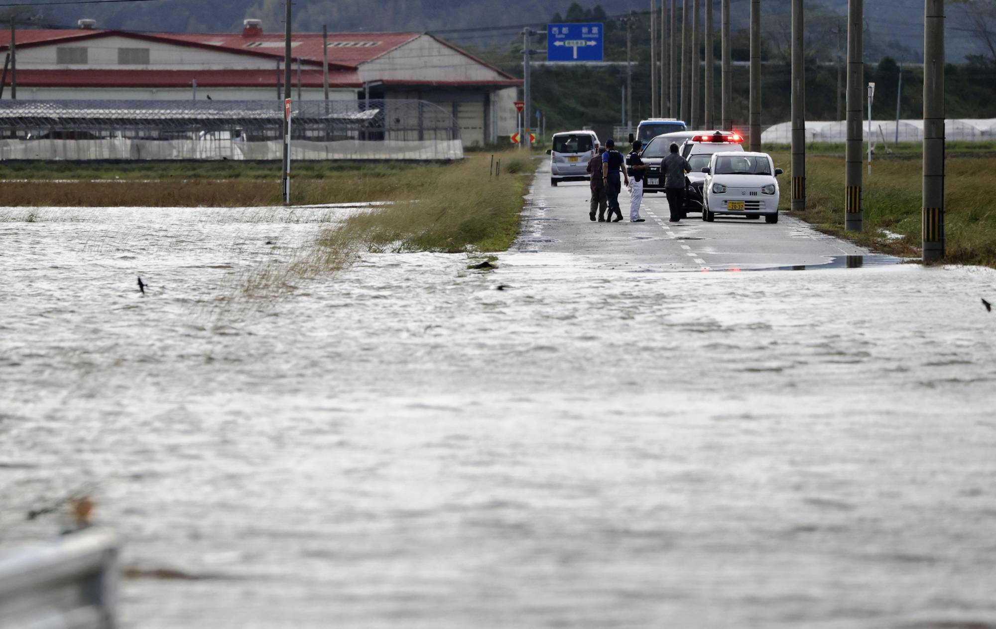 A road is partially flooded in the town of Saito in Miyazaki Prefecture on Monday. | KYODO