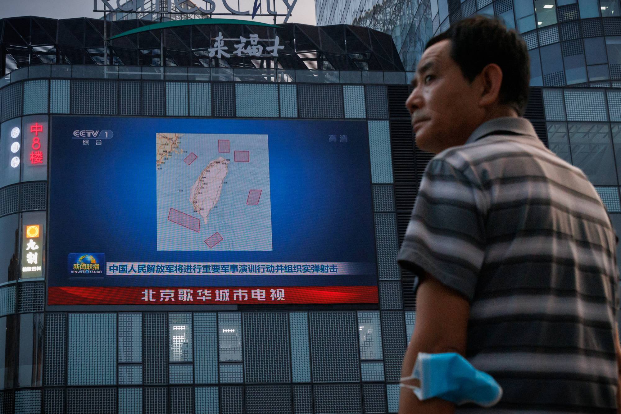 A screen in Beijing shows a CCTV news broadcast featuring a map of locations around Taiwan where the Chinese People's Liberation Army was to conduct military exercises and training activities including live-fire drills. | REUTERS 
