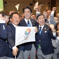 Abe and other delegation members celebrate the announcement of the International Olympic Committee choosing Tokyo to host the 2020 Olympic and Paralympic Games in Buenos Aires in September 2013. | KYODO
