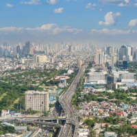 Metro Manila, Philippines - April 2022: The SLEX Skyway going towards the vast Metro Manila cityscape and skyline.