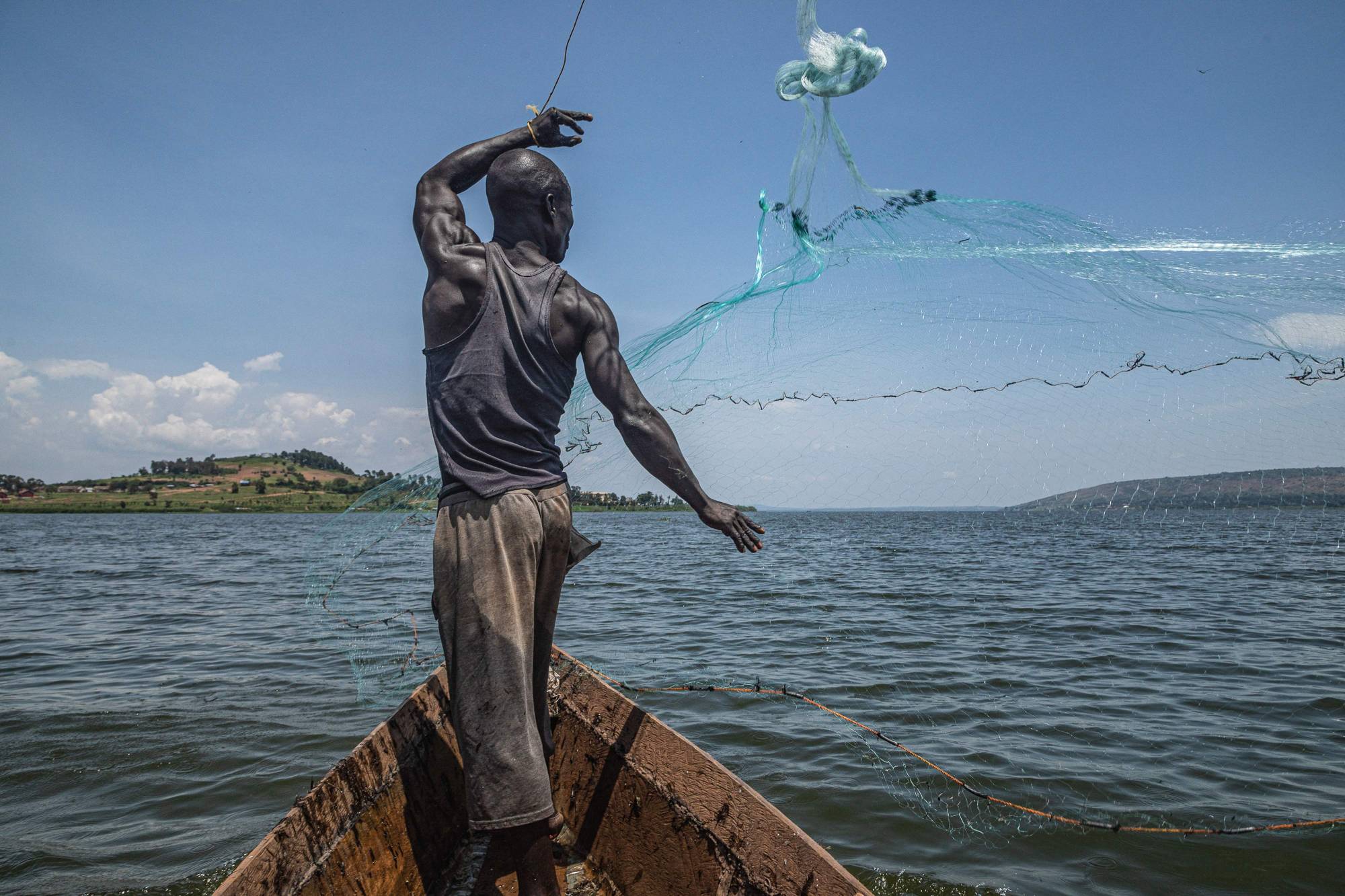 Jowali Kitagenda, 40, casting his net to catch fish on the Nile River in Jinja, Uganda, on Oct. 7. A report published by the Nile Basin Initiative last year raised alarm bells over rising industrial pollution, with government regulations allowing factory owners to set up shop within 100 meters of the river bank. | AFP-JIJI