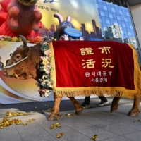 A man leads a bull during a ceremony celebrating the New Year\'s opening of the South Korea stock market in Seoul on Jan. 2.  | AFP-JIJI