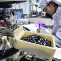 Semiconductor chips sit in a container on the production line at the Hana Microelectronics plant at the Hi-Tech Industrial Estate in Thailand. | BLOOMBERG