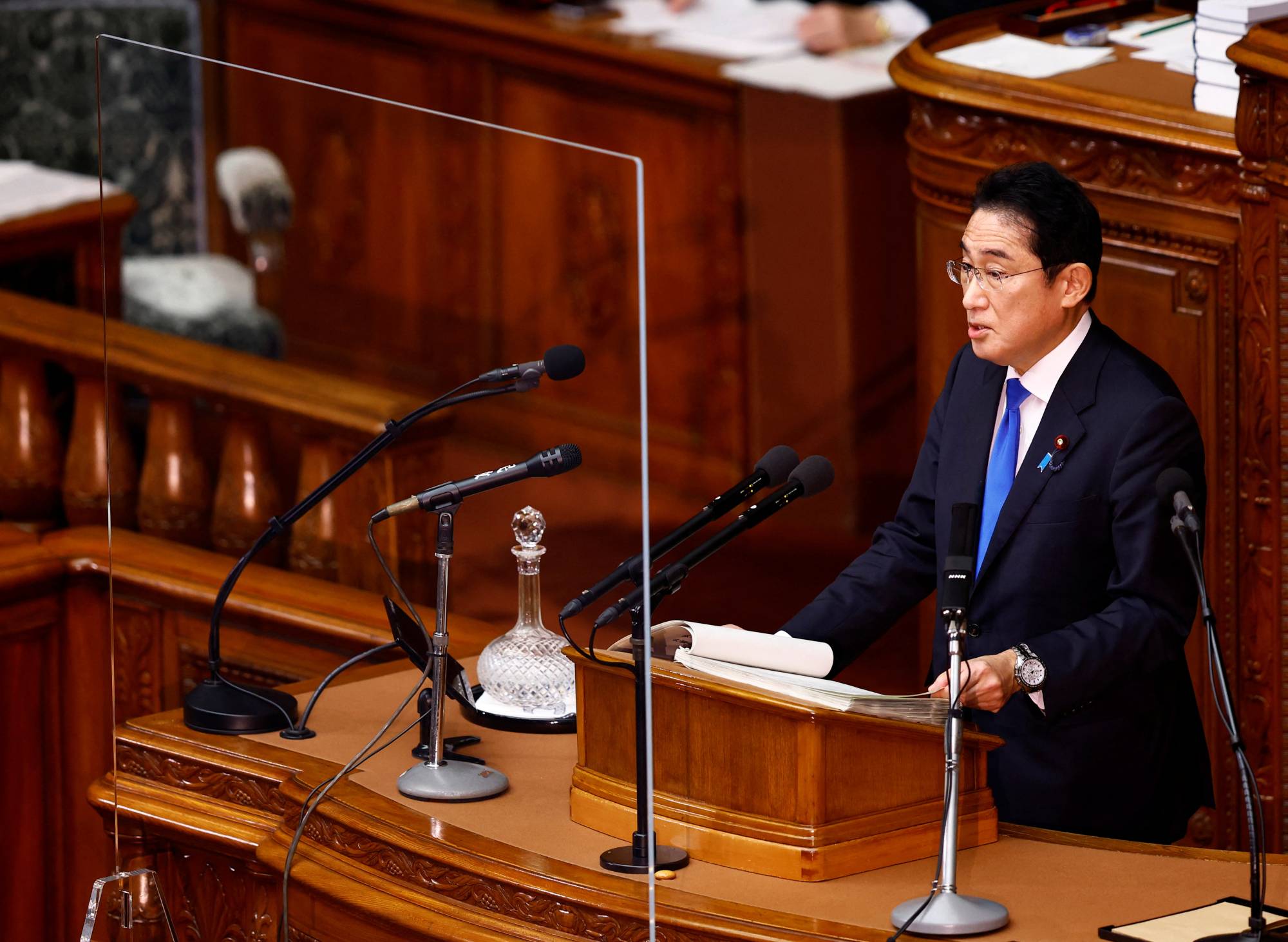 Prime Minister Fumio Kishida delivers his policy speech on the first day of the new parliamentary session at the Lower House on Monday. Those making speeches are no longer are required to wear a mask. | REUTERS
