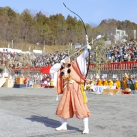 A female archer shoots rubber-tipped arrows as part of the process of spiritual cleansing and renewal.