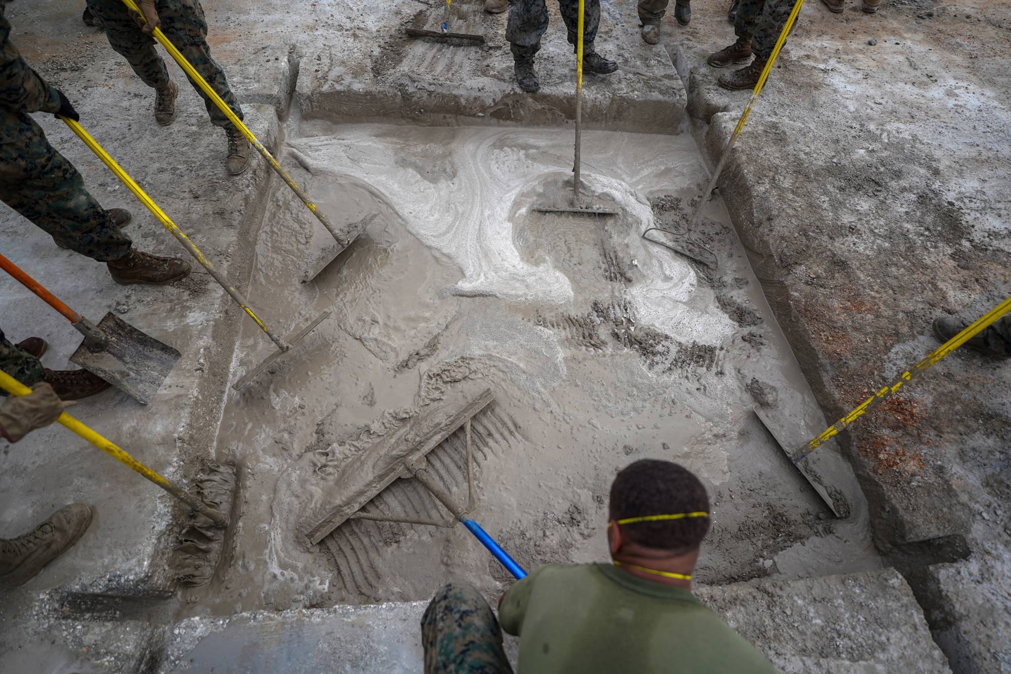 American and Japanese airmen train on runway repair with rapid-setting concrete on the Pacific isle of Tinian, Northern Mariana Islands, on Feb. 17. | CHANG W. LEE / THE NEW YORK TIMES