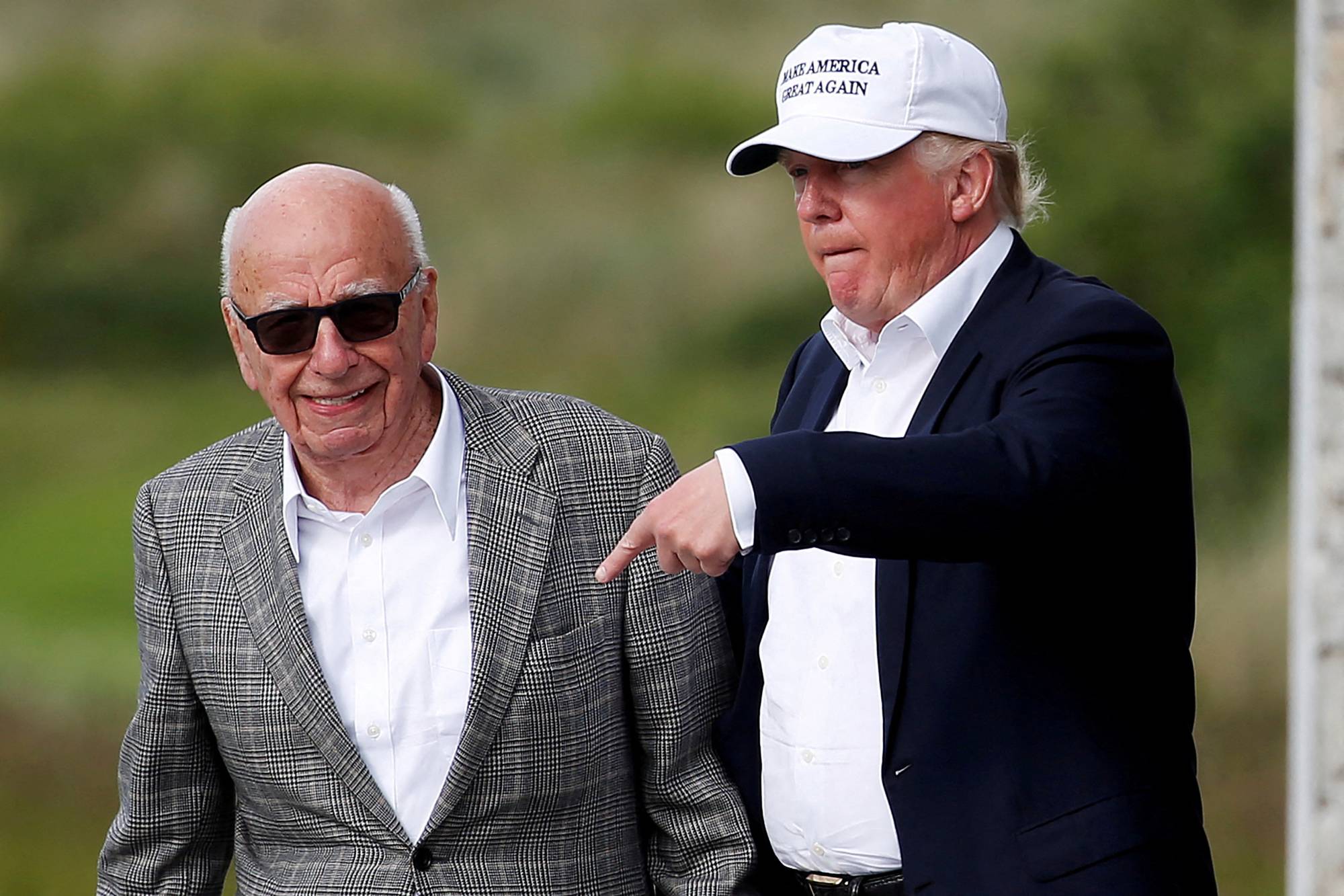 Then-U.S. presidential candidate Donald Trump (right) speaks to media mogul Rupert Murdoch as they walk out of Trump International Golf Links in Aberdeen, Scotland, in June 2016. | REUTERS