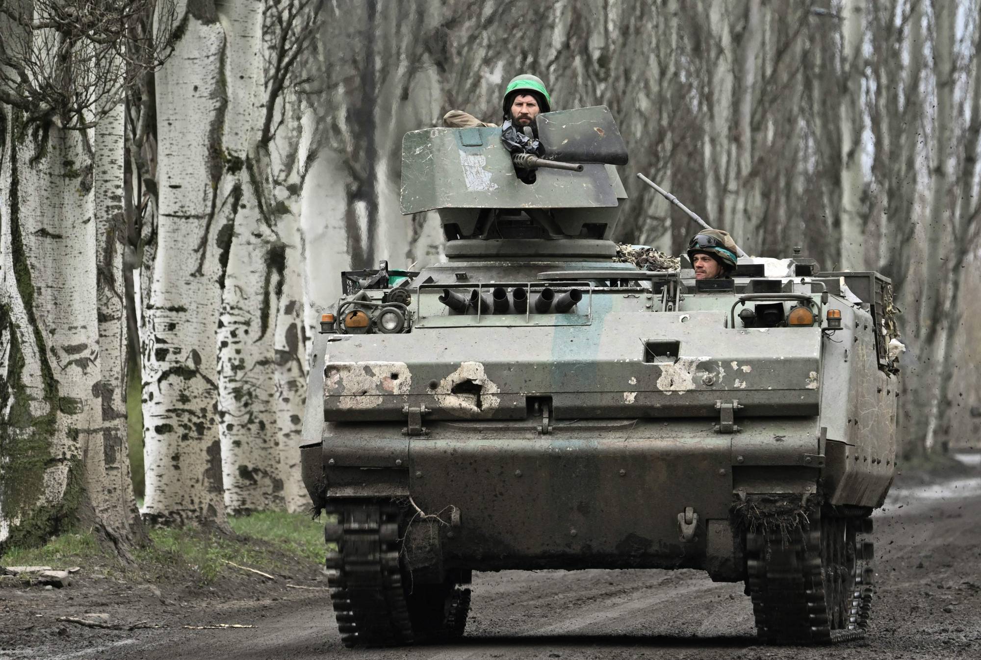 Ukrainian servicemen ride on Dutch YPR-765 armored personnel carrier on a road near Bakhmut, in Ukraine's Donetsk region, on Thursday. | AFP-JIJI