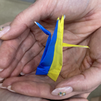 An origami crane in Ukrainian national colors represents hopes for peace.