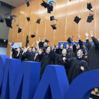 Students toss their caps upon graduating from Chuo’s Faculty of Global Management. | CHUO UNIVERSITY