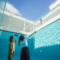 Visitors gaze up from 'The Swimming Pool' by Leandro Erlich at the 21st Century Museum of Contemporary Art, Kanazawa.