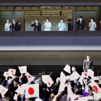 The emperor (third from left), empress (fourth from left), Princess Aiko (fifth from left) and other imperial family members wave to well-wishers from a balcony at Tokyo’s Imperial Palace during a New Year’s greeting event on Jan. 2. | KYODO
