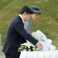 Then-Crown Prince Naruhito and then-Crown Princess Masako offer flowers at a cenotaph for the victims of the 2011 Great East Japan Earthquake and tsunami in Natori, Miyagi Prefecture, on Nov. 1, 2017. | KYODO