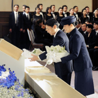 Then-Crown Prince Naruhito and then-Crown Princess Masako offer flowers during a ceremony marking the anniversary of the 1995 Great Hanshin Earthquake on Jan. 17, 2010. | KYODO