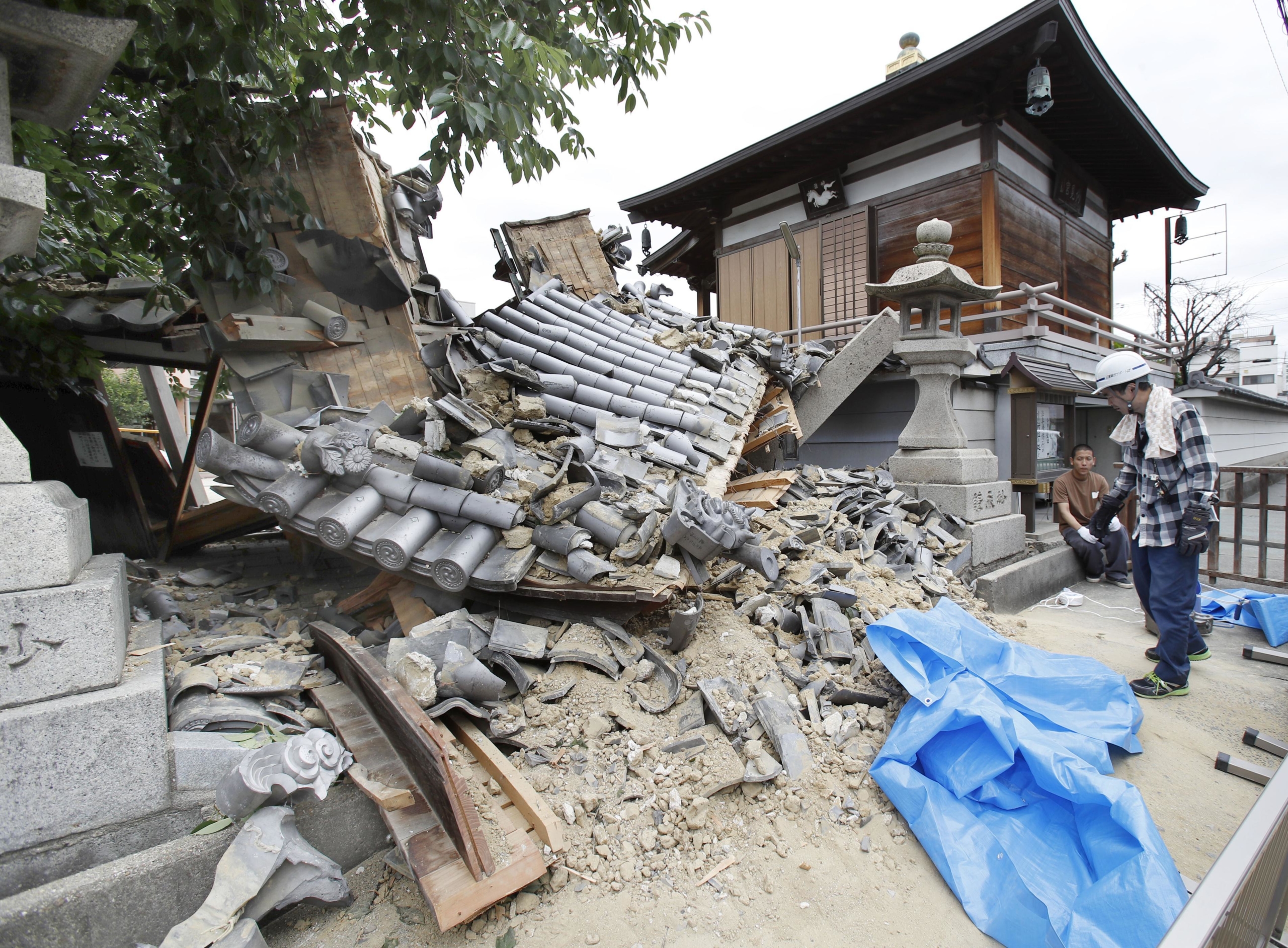 The gate of a temple collapses after an earthquake hit Ibaraki city, Osaka Prefecture, on June 18, 2018. | KYODO