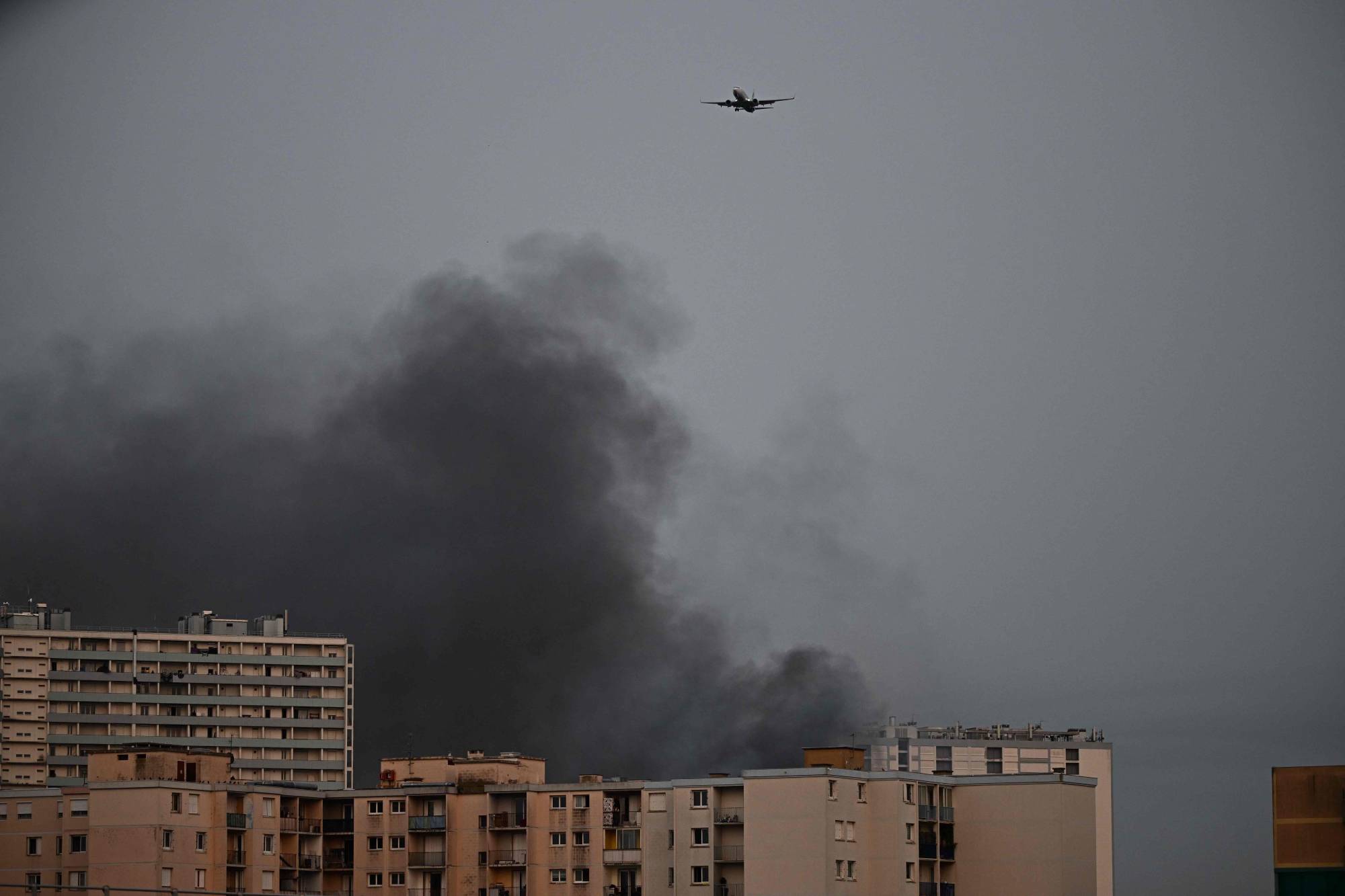 طائرة تحلق فوق الدخان المتصاعد في منطقة سكنية في تولوز ، جنوب غرب فرنسا ، اليوم الأربعاء. | وكالة الأنباء الفرنسية- JIJI