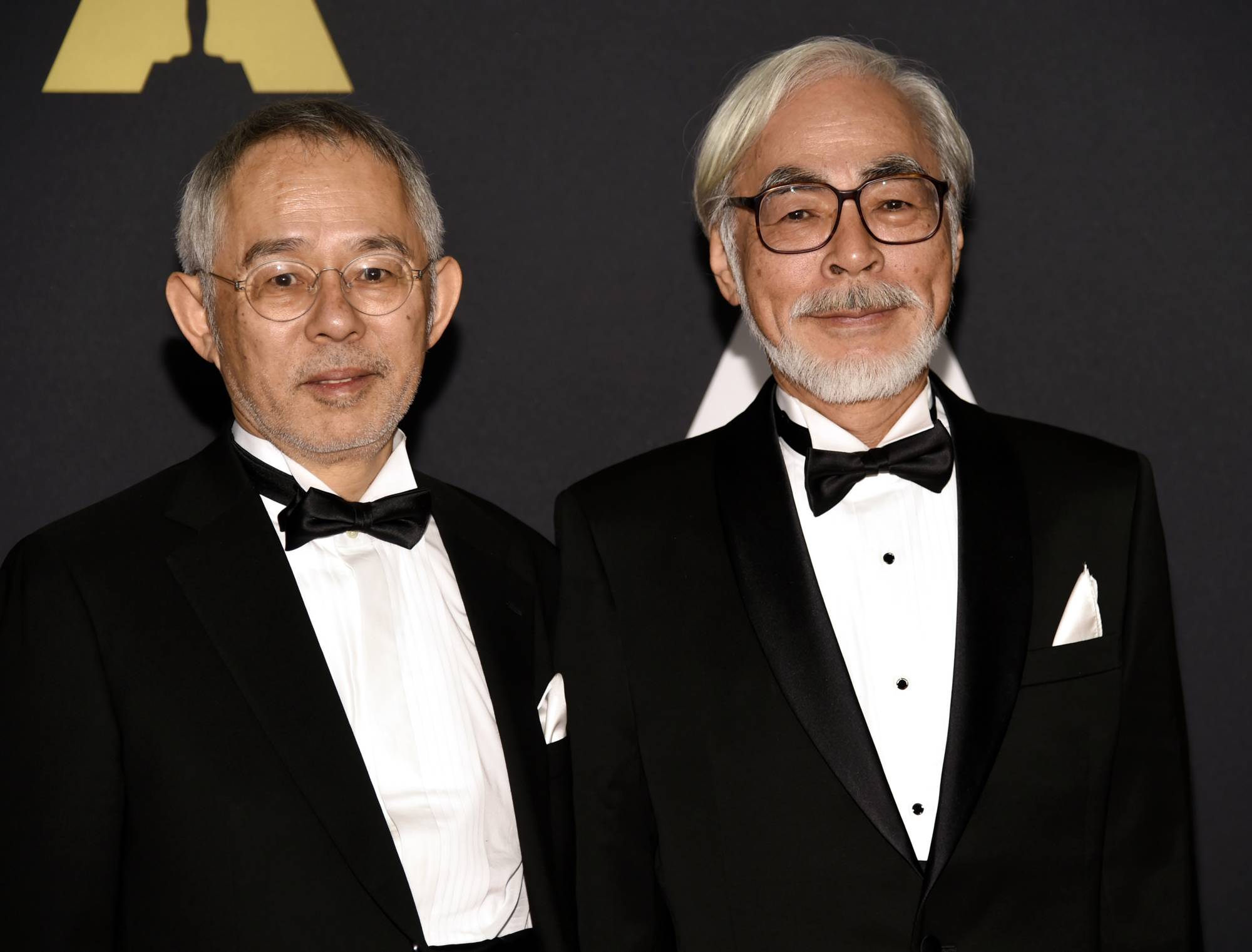 Film producer Toshio Suzuki (left), a long-time colleague of Hayao Miyazaki (right), poses with the animator at an awards ceremony in Los Angeles in 2014. | REUTERS
