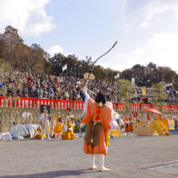 A female mountain priest shoots arrows to exorcise evil spirits from the festival venue.