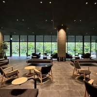 The furniture, made locally in Kyushu, and colors of Unzen Miyazaki Ryokan's lobby are neutral to allow guests to better enjoy the beautiful views of the Japanese garden and the mountains beyond.