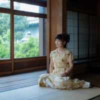 Biwako Biennale founder and General Director Yoko Nakata admires a garden from her office, which also serves as an exhibition venue during the art festival, in Omihachiman Old Town. | TAKAO OHTA