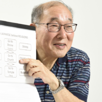 Takagi shows a guidebook he created that covers points of interest on his tours. | ARC COMMUNICATIONS CO.